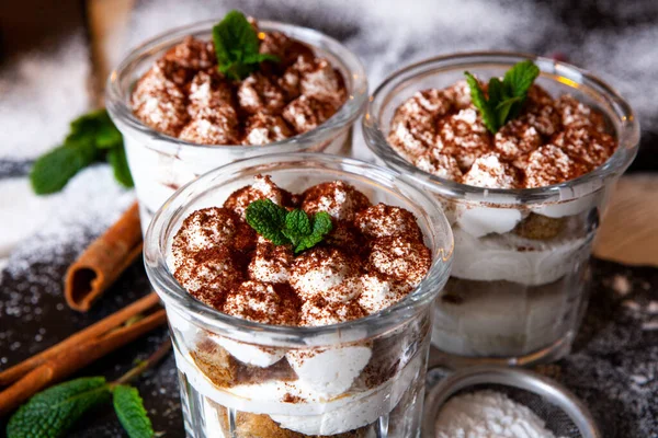 Tiramisu cake in glass, classic Italian dessert with mascarpone cream and cocoa. selective focus.
