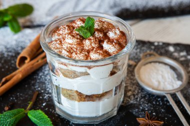 Tiramisu cake in glass, classic Italian dessert with mascarpone cream and cocoa. selective focus.