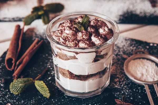 Tiramisu cake in glass, classic Italian dessert with mascarpone cream and cocoa. selective focus.