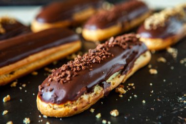 Traditional french eclairs with chocolate. Tasty dessert. Home made cake eclairs Sweet. Dessert. Pastry filled with cream. Chocolate icing.