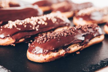Traditional french eclairs with chocolate. Tasty dessert. Home made cake eclairs Sweet. Dessert. Pastry filled with cream. Chocolate icing.
