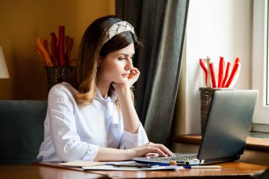 Kız bir kafedeki bilgisayarın başında çalışıyor. Öğrenci çevrimiçi öğreniyor. Blogcu. Genç beyaz kadın yazar dizüstü bilgisayarda klavye çalıyor. Mola sırasında taşınabilir bilgisayar kullanan çekici bir iş kadını..