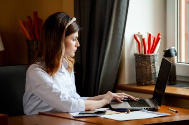 Kız bir kafedeki bilgisayarın başında çalışıyor. Öğrenci çevrimiçi öğreniyor. Blogcu. Genç beyaz kadın yazar dizüstü bilgisayarda klavye çalıyor. Mola sırasında taşınabilir bilgisayar kullanan çekici bir iş kadını..