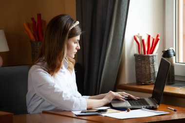 Kız bir kafedeki bilgisayarın başında çalışıyor. Öğrenci çevrimiçi öğreniyor. Blogcu. Genç beyaz kadın yazar dizüstü bilgisayarda klavye çalıyor. Mola sırasında taşınabilir bilgisayar kullanan çekici bir iş kadını..