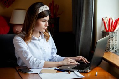 Kız bir kafedeki bilgisayarın başında çalışıyor. Öğrenci çevrimiçi öğreniyor. Blogcu. Genç beyaz kadın yazar dizüstü bilgisayarda klavye çalıyor. Mola sırasında taşınabilir bilgisayar kullanan çekici bir iş kadını..