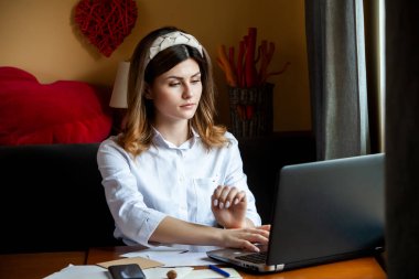 Kız bir kafedeki bilgisayarın başında çalışıyor. Öğrenci çevrimiçi öğreniyor. Blogcu. Genç beyaz kadın yazar dizüstü bilgisayarda klavye çalıyor. Mola sırasında taşınabilir bilgisayar kullanan çekici bir iş kadını..