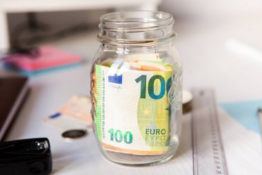 Coronavirus COVID-19 nedeniyle ekonomik kriz konsepti. Finansal kriz. Şişede para biriktiriyorum. Cam şişenin içinde para tasarrufu. Bir cam konseptte Euro para notları.. 