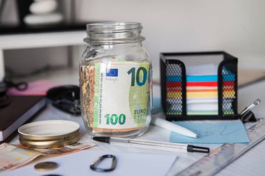 Coronavirus COVID-19 nedeniyle ekonomik kriz konsepti. Finansal kriz. Şişede para biriktiriyorum. Cam şişenin içinde para tasarrufu. Bir cam konseptte Euro para notları.. 