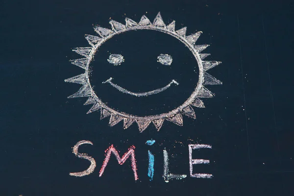 Smile icon painted. Smiling emoticon. SMILE message word on a wooden desk.