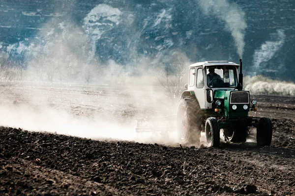 Farmer in tractor preparing land. Agricultural works at farmlands. agricultural work plowing land on a  tractor. Tractor on a farmer field in Moldova, Europe.