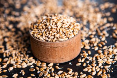 Tam tahıllı un izole edilmiş. Arkaplan dokusu olarak buğday taneleri, üst görünüm.