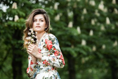 Rüzgarda hareket eden kıllı bir kadın portresi. Yeşil Park 'taki güzel Rus esmer kızın yakın plan portresi. Avrupalı beyaz kadın. 