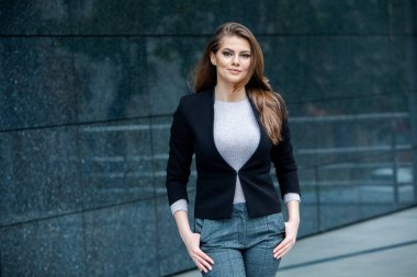 Kendine güvenen bir iş uzmanı. Ofis binasının yakınında başarılı bir profesyonel pozu. Avrupalı kız. Rus iş kadını. Kadın iş adamı konsepti. Başarılı İş Kadının Portresi