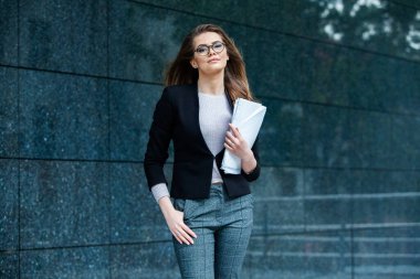 Kendine güvenen bir iş uzmanı. Ofis binasının yakınında başarılı bir profesyonel pozu. Avrupalı kız. Rus iş kadını. Kadın iş adamı konsepti. Başarılı İş Kadının Portresi