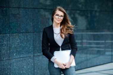 Kendine güvenen bir iş uzmanı. Ofis binasının yakınında başarılı bir profesyonel pozu. Avrupalı kız. Rus iş kadını. Kadın iş adamı konsepti. Başarılı İş Kadının Portresi