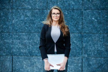 Kendine güvenen bir iş uzmanı. Ofis binasının yakınında başarılı bir profesyonel pozu. Avrupalı kız. Rus iş kadını. Kadın iş adamı konsepti. Başarılı İş Kadının Portresi