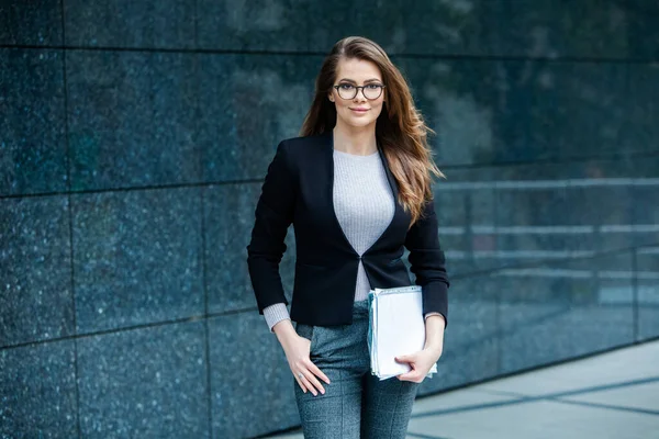 Kendine güvenen bir iş uzmanı. Ofis binasının yakınında başarılı bir profesyonel pozu. Avrupalı kız. Rus iş kadını. Kadın iş adamı konsepti. Başarılı İş Kadının Portresi