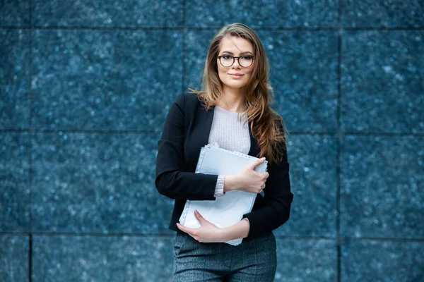 Kendine güvenen bir iş uzmanı. Ofis binasının yakınında başarılı bir profesyonel pozu. Avrupalı kız. Rus iş kadını. Kadın iş adamı konsepti. Başarılı İş Kadının Portresi