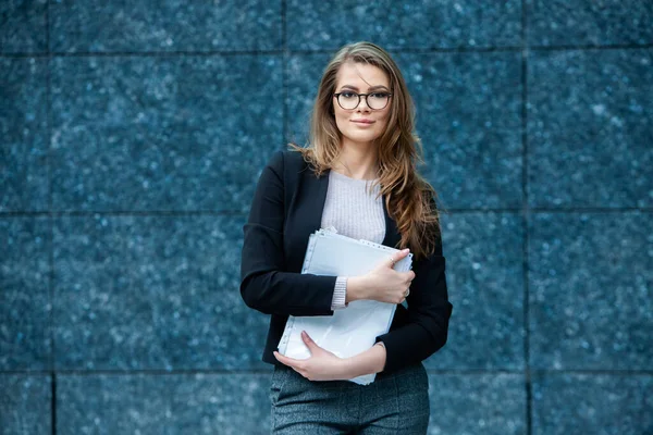 Kendine güvenen bir iş uzmanı. Ofis binasının yakınında başarılı bir profesyonel pozu. Avrupalı kız. Rus iş kadını. Kadın iş adamı konsepti. Başarılı İş Kadının Portresi