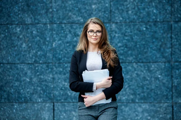 Kendine güvenen bir iş uzmanı. Ofis binasının yakınında başarılı bir profesyonel pozu. Avrupalı kız. Rus iş kadını. Kadın iş adamı konsepti. Başarılı İş Kadının Portresi