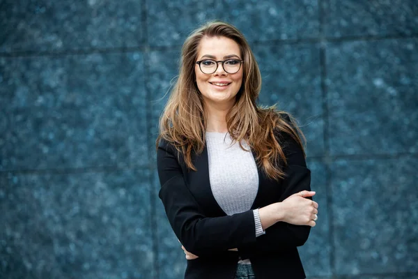 Kendine güvenen bir iş uzmanı. Ofis binasının yakınında başarılı bir profesyonel pozu. Avrupalı kız. Rus iş kadını. Kadın iş adamı konsepti. Başarılı İş Kadının Portresi