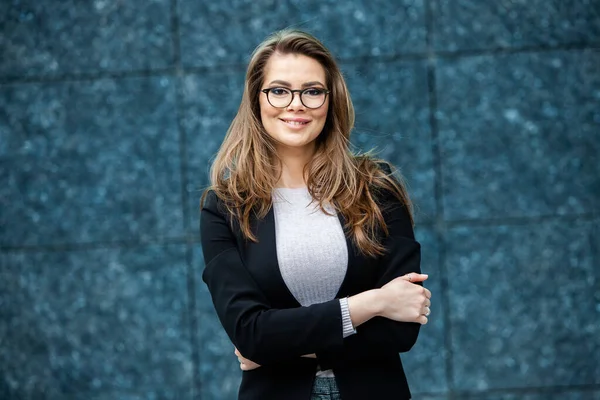 Kendine güvenen bir iş uzmanı. Ofis binasının yakınında başarılı bir profesyonel pozu. Avrupalı kız. Rus iş kadını. Kadın iş adamı konsepti. Başarılı İş Kadının Portresi
