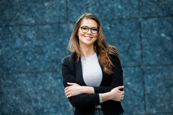 Kendine güvenen bir iş uzmanı. Ofis binasının yakınında başarılı bir profesyonel pozu. Avrupalı kız. Rus iş kadını. Kadın iş adamı konsepti. Başarılı İş Kadının Portresi