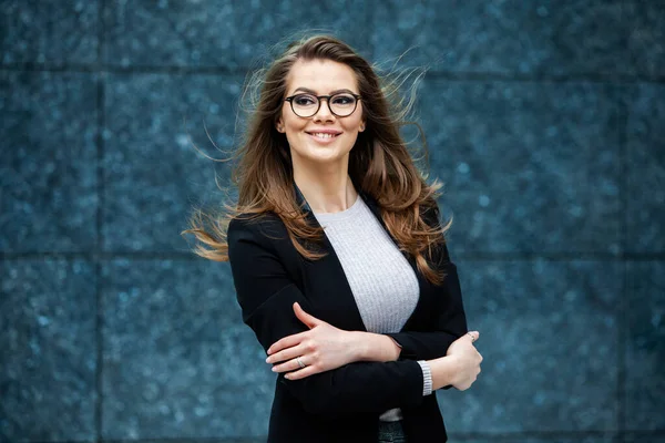 Kendine güvenen bir iş uzmanı. Ofis binasının yakınında başarılı bir profesyonel pozu. Avrupalı kız. Rus iş kadını. Kadın iş adamı konsepti. Başarılı İş Kadının Portresi