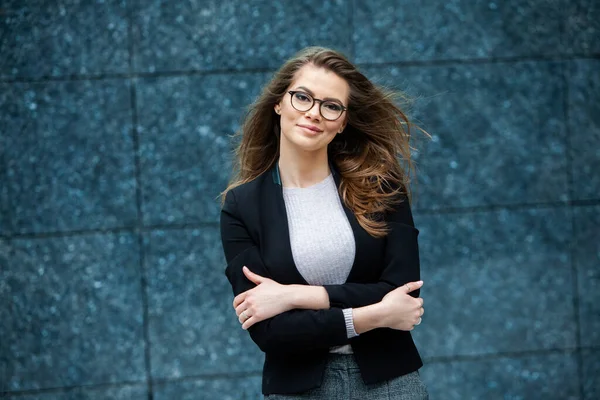 Kendine güvenen bir iş uzmanı. Ofis binasının yakınında başarılı bir profesyonel pozu. Avrupalı kız. Rus iş kadını. Kadın iş adamı konsepti. Başarılı İş Kadının Portresi