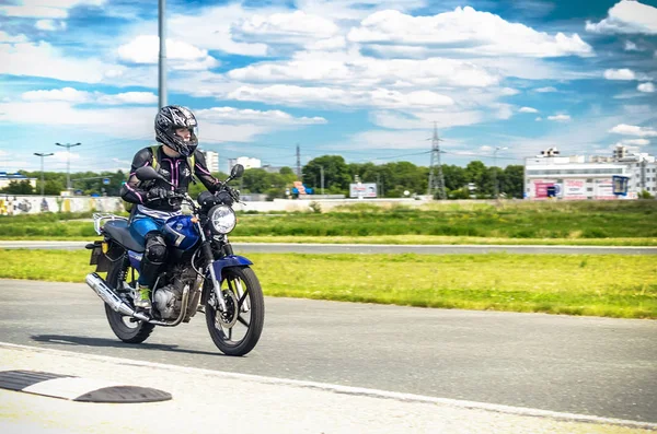 Ulyanovsk, Rússia - 10 de junho de 2017. Menina em uma corrida jaqueta preta em uma motocicleta azul em uma pista de esportes . — Fotografia de Stock