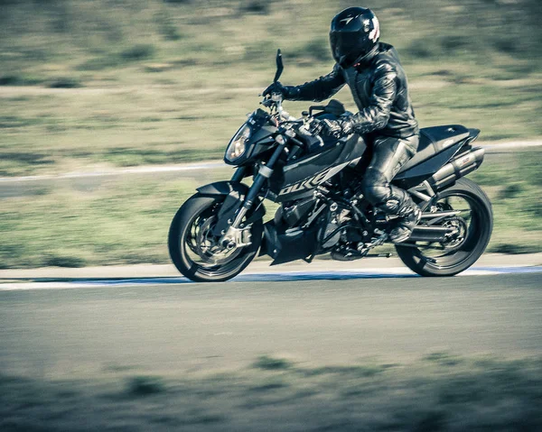 Ulyanovsk, Rússia - 19 de agosto de 2017. Um motociclista em uma motocicleta clássica preta treina em uma pista de esportes. Desfoque de movimento . — Fotografia de Stock