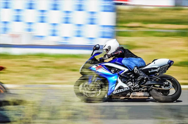 Ulyanovsk, Rusia - 19 de agosto de 2017. Un motociclista con una mochila entrena en una motocicleta en una pista deportiva. Suzuki GSX-R. Desenfoque de movimiento . —  Fotos de Stock