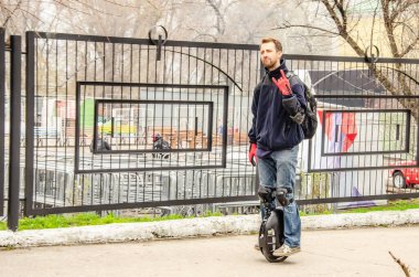 Ulyanovsk, Rusya - 03 Mayıs 2019: Motosiklet sezonunun açılışı - otomobil fuarı. Tek tekerli bir araçla kaldırıma çıkan genç bir adam..
