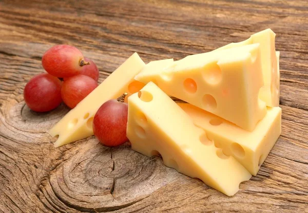 木製の背景のブドウとエメンタール チーズ — ストック写真