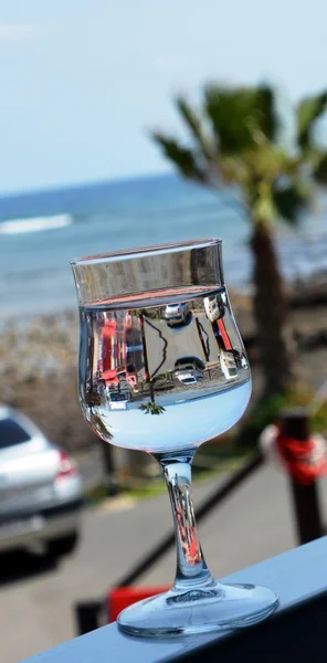 Reflexão do mar e palmeira em um copo . — Fotografia de Stock