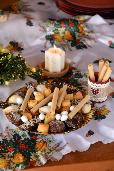 Biscotti di Natale su un piatto decorato su un tavolo e candela accesa bianca — Foto Stock