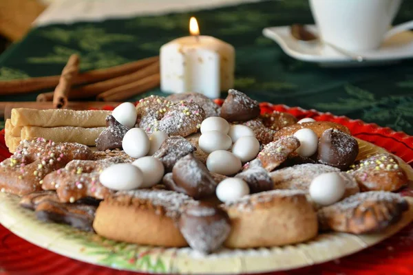 Detail der leckeren Weihnachtsplätzchen mit Tasse Kaffee auf einem Tisch mit Kerze auf weißem Ton. — Stockfoto