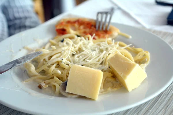 Italiensk spagetti med ost och liten pizza. Utsökt mat. — Stockfoto