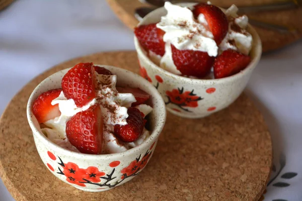 Gehakte aardbeien en licht opgeklopte room, verse heerlijk dessert. — Stockfoto