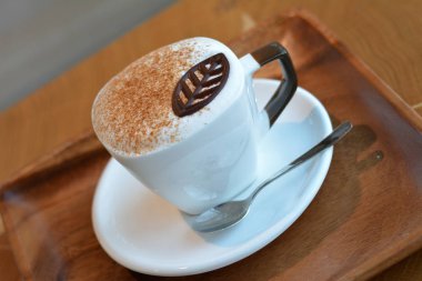 Lezzetli köpüklü cappuccino bir plaka üzerinde beyaz bir Kupası.