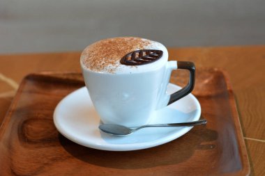 Lezzetli köpüklü cappuccino bir plaka üzerinde beyaz bir Kupası.