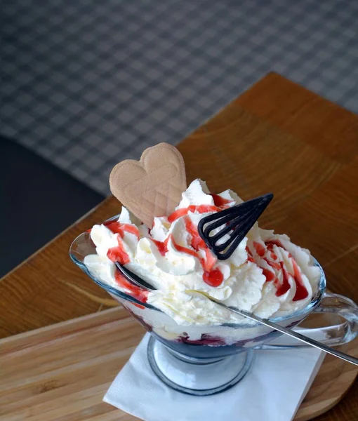 Mirtilos quentes com sorvete de baunilha e chantilly em uma tigela de vidro . — Fotografia de Stock