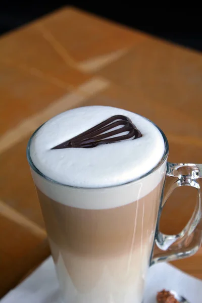 Latte Macchiato en copa de vidrio en una mesa de madera — Foto de Stock