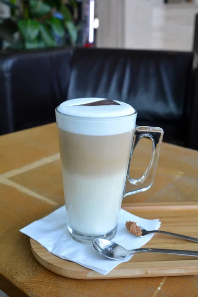 Latte Macchiato sur une tasse en verre sur une table en bois — Photo