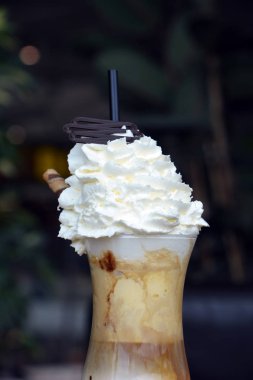 Bir cam bardak krem şanti ile lezzetli buzlu kahve.