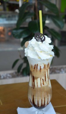 Bir cam bardak krem şanti ile lezzetli buzlu kahve.