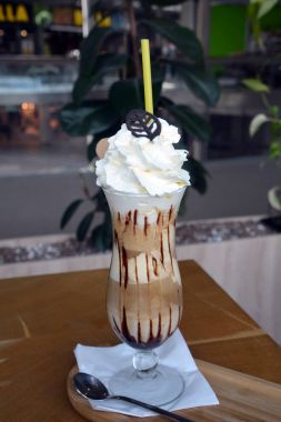 Bir cam bardak krem şanti ile lezzetli buzlu kahve.