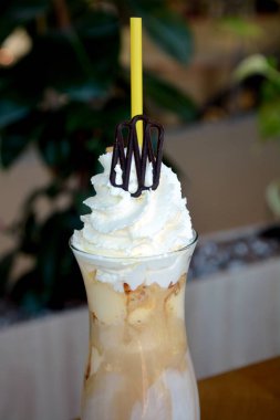 Bir cam bardak krem şanti ile lezzetli buzlu kahve.