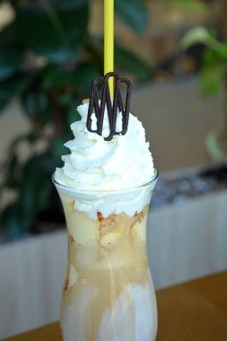 Bir cam bardak krem şanti ile lezzetli buzlu kahve.