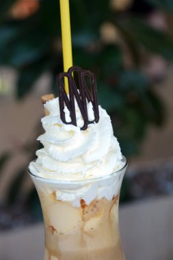 Bir cam bardak krem şanti ile lezzetli buzlu kahve.